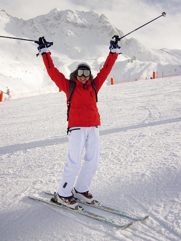 person with hands in air and wearing skis